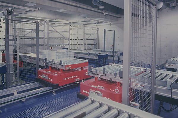 Containers with books being transferred via STV from the mini load AS/RS to an I/O station