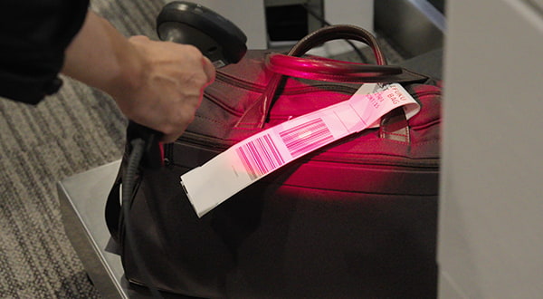 Register the baggage tag using the handheld scanner.